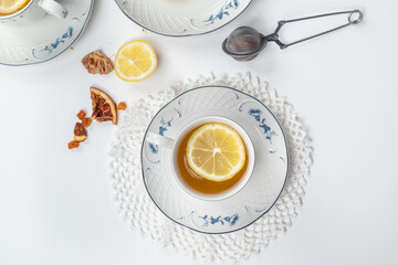 Still life with fine porcelain tea cups and accessories on a textured white background - 764139571