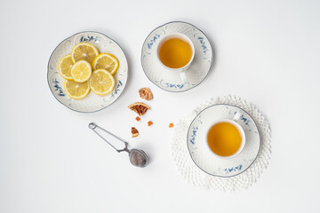 Still life with fine porcelain tea cups and accessories on a textured white background - 764139587