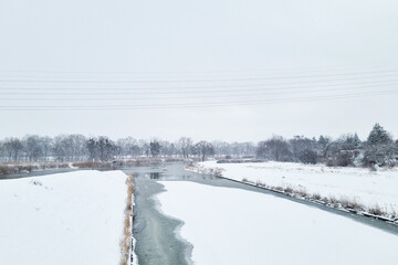 Snow Covered Field With River Running Through