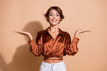 Photo of sweet pretty lady dressed silky shirt comparing arms empty space isolated beige color background - 764147173