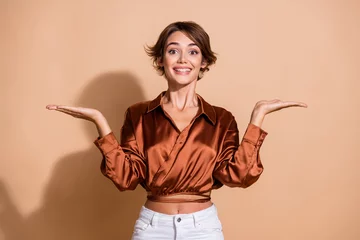 Foto auf Acrylglas Höhenskala Photo of sweet pretty lady dressed silky shirt comparing arms empty space isolated beige color background