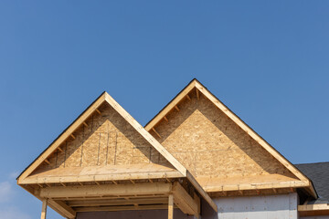 Dormers of a residential construction project showing plywood roof and oriented strand board or...