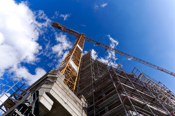 Looking up yellow crane at construction site of apartment building at Swiss City of Zürich on a...
