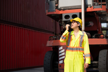 Asia logistic engineer man worker or foreman working with walkie talkie at container site	 - 764160750