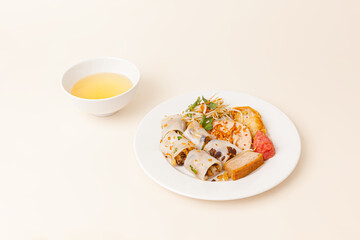 Banh Cuon, Vietnamese steamed rice rolls pancake with savory mixture of ground pork, Vietnamese food isolated on white background, perspective view