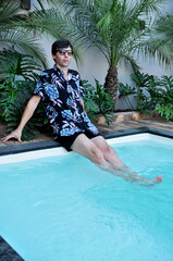 homem relaxando em piscina com paisagismo tropical no verão 