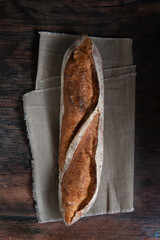 French baguette on a wooden dark background. 
