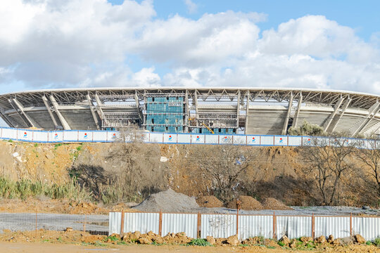 Algiers, Algeria- January 22, 2023: Douera stadium of MCA Algerian soccer club under construction vue from the freeway on cheraga road. Cloudy blue sky, clear sunny day, trees and plants in dried soil