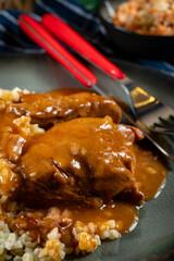 Braised pork neck in own sauce served with barley groats and salad.
