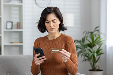 Concerned woman checking credit card after online fraud