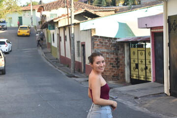Mujer joven caminando por un pueblo m&aacute;gico disfrutando del clima  