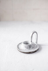 An empty ceramic candlestick on a light background.