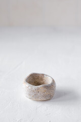 a small ceramic saucer/candlestick/bowl on a light background. Close-up