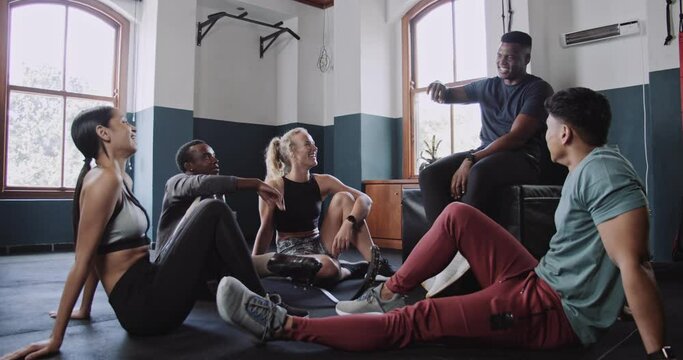 Fitness trainer explains workout plan to group in fitness studio 