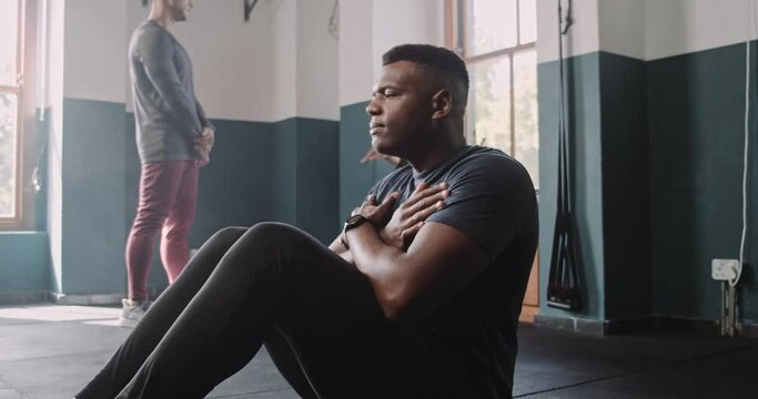 African athlete performs sit-ups in fitness studio 