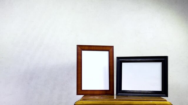 two Empty ornate picture frame on wood table with window shadow