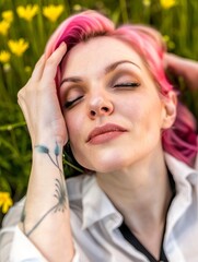 A young woman with pink hair is resting while lying in a field with tall grass and wild flowers.
Concept: Youth culture, summer festivals and freedom of expression. psychological and meditation