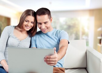 Happy young couple with computer laptop at home