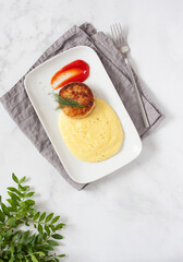 Traditional Russian cuisine, fried cutlet with mashed potatoes on a plate in a cafe. View from above. School lunch. A mockup with space for text.