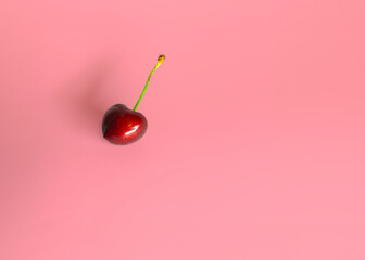 red cherry with a glossy surface and a green stem, its sweet ripeness suggested by its deep red...