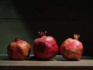 Red organic grown pomegranates in bright sunlight with copyspace. Natural fruit concept image.
