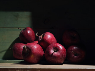 Red organic grown apples with in wooden box in bright sunlight with copyspace. Natural fruit from garden concept image.