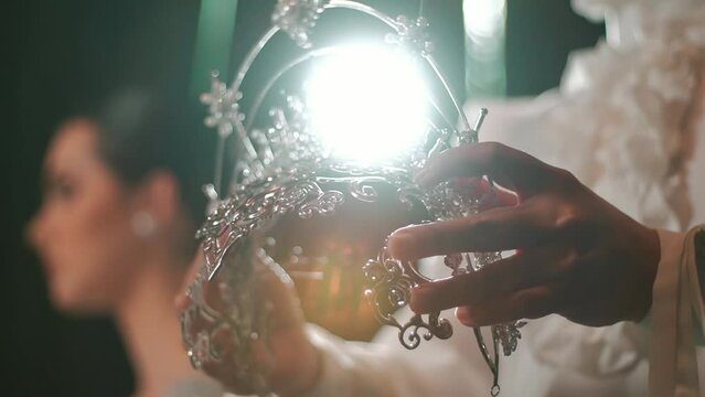 Elegant bride holding a sparkling tiara, symbolizing wedding preparation and luxury.