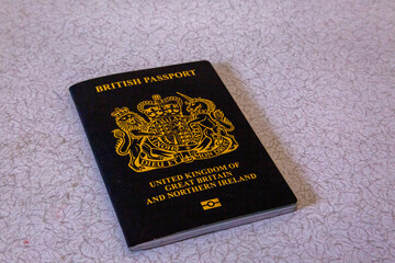 New British passport of post-Brexit blue black UK passport cover with against light background
