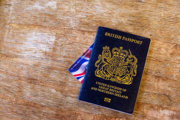 New British passport of post-Brexit blue black UK passport cover with against wooden background...