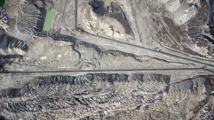Aerial view of open mine pit. Drone shot of coal mining activity. Water Pollution. Extraction. Destroyed landscape. Apocalyptic environment. Disruption of nature.