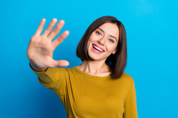 Photo of pretty friendly lady dressed shirt smiling waving arm palm hi isolated blue color...