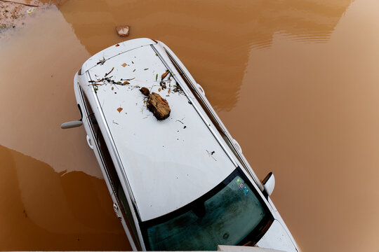 Torrential rain causes flash floods in the city area. Cars under water in the condominium parking lot. Damaged cars caused by heavy rainfall. Buildings surrounded by water.