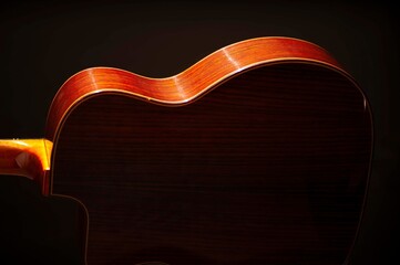 Obraz premium Classical Spanish flamenco guitar close up, dramatically lit isolated on black background with copy space.