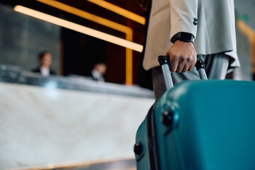 Close up of black man with suitcase arriving at hotel.