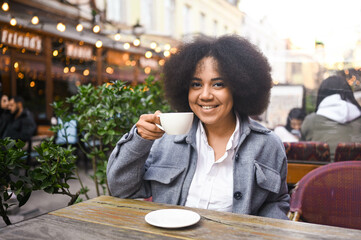 Fashion street style portrait of attractive young natural beauty African American woman with afro...