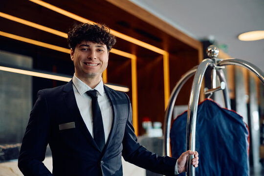 Young happy bellboy working in  hotel and looking at camera.