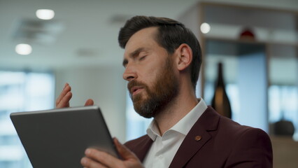 Disappointed employee face palming at lobby closeup. Man watching tablet screen