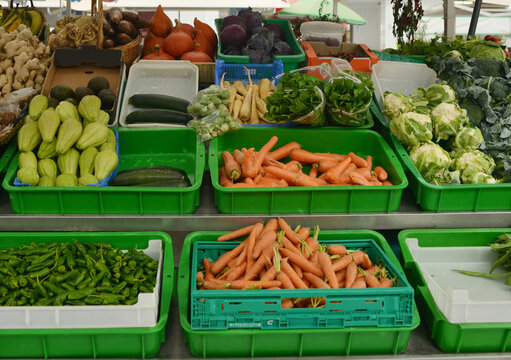 Market stall display with an selection of fresh vegetables, pumpkin, cauliflower, carrots, peppers and salad in portugal