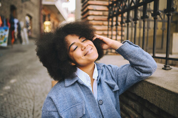 Fashion street style portrait of attractive young natural beauty African American woman with afro...