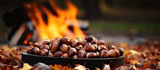 Zelfklevend Fotobehang Bowl of assorted nuts by a blazing fire © Ilgun