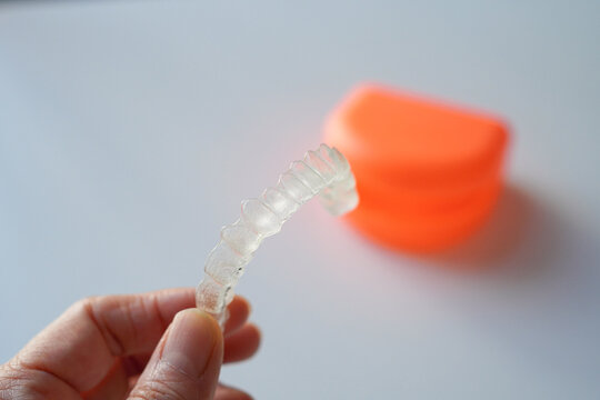 歯列矯正のマウスピース　インビザラインを持つ女性の手