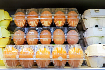close-up of farm chicken eggs in plastic containers on the store counter