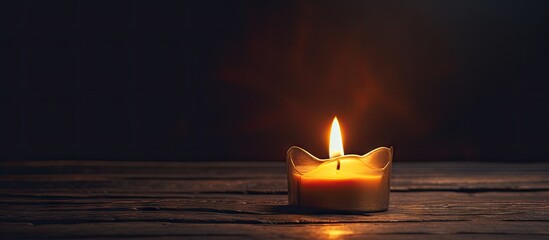 A flickering candle on a wooden surface