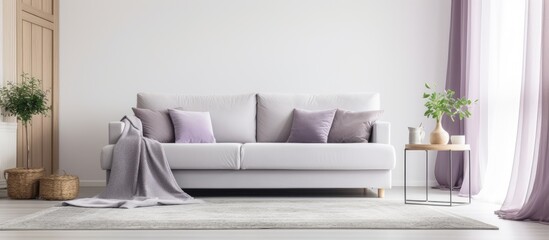 A white couch with purple pillows and a blanket in a living room