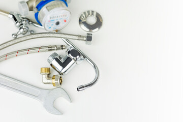 Plumbing parts, accessories and tools on a white background with copy space.