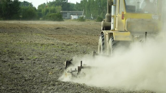 A large powerful tractor plows the ground. Rural nature. Preparation of soil.