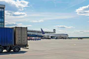 Airplane delivering containers at the airport background. Cargo freight plane flight air transportation delivery, aircraft transport logistics and global trade commercial shipping industry concept.