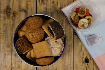 Top view of a tin box with pastries and dried fruits.