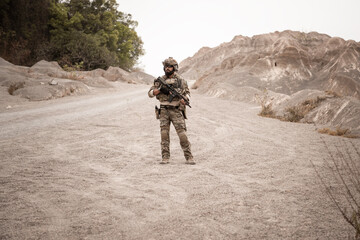 Soldiers in camouflage uniforms aiming with their rifles.ready to fire during military operation in the desert , soldiers training  in a military operation