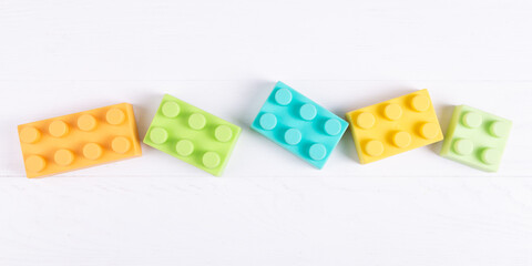 Children's colored blocks, construction set, on white background, copy space. Educational baby toy.